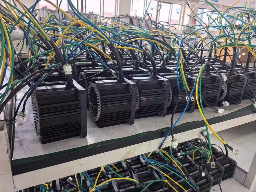Servo-style motors with wired harnesses on the bench